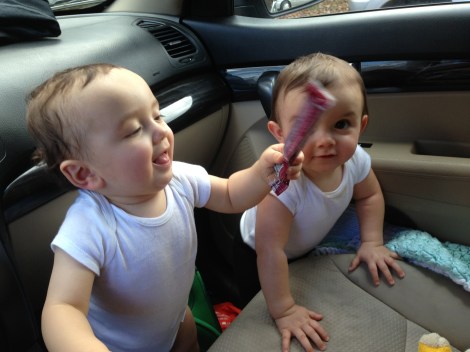 twins playing in car